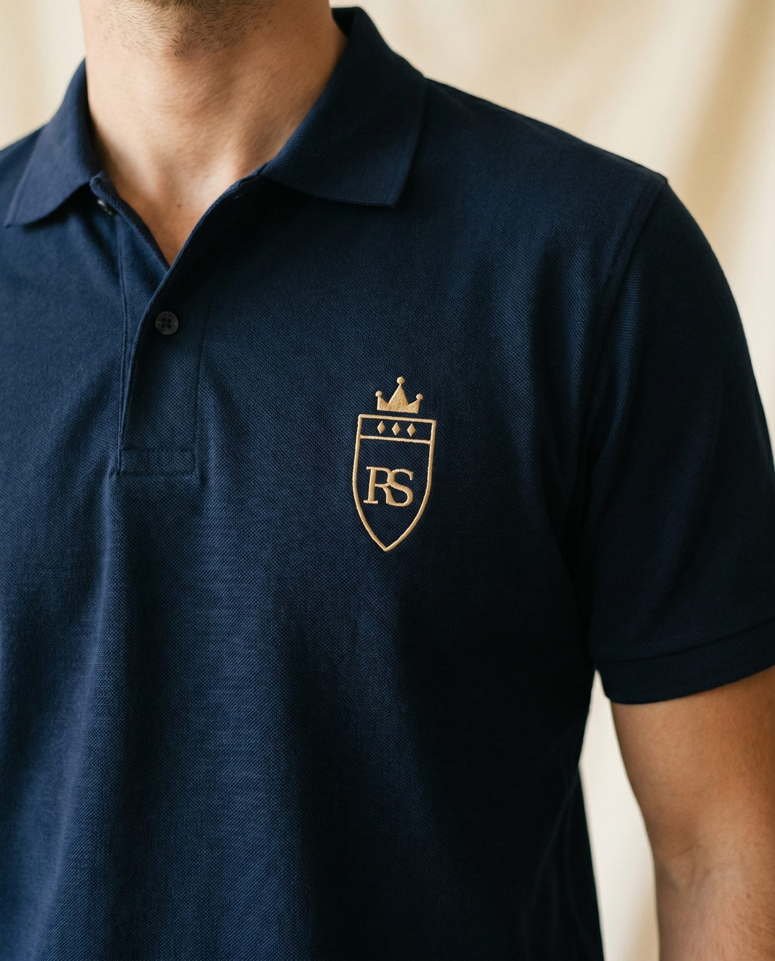Polo piqué marine brodé RS porté — pièce d'ancrage du vestiaire capsule Maison Sahari