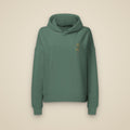 Sweat à capuche femme vert sauge brodé du monogramme RS, vue de face sur fond pierre — Maison Sahari
