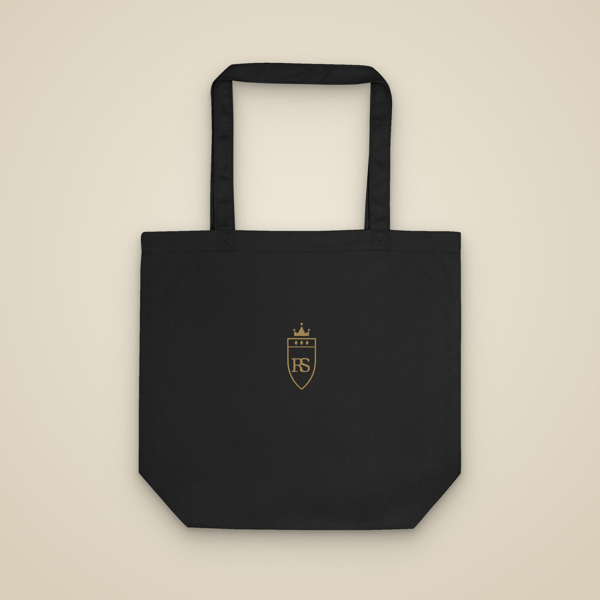 Tote bag noir brodé du monogramme RS, vue de face sur fond pierre — Maison Sahari